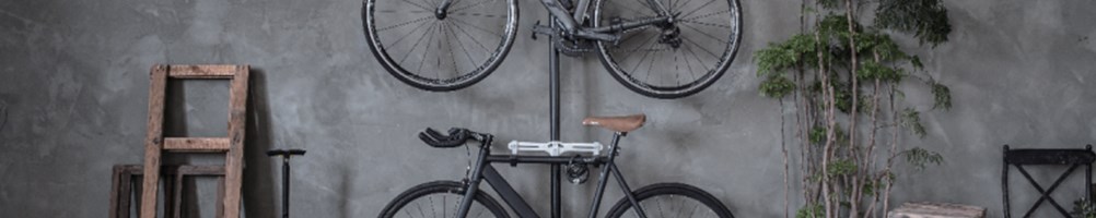 Two road bikes hanging on wall mounted storage